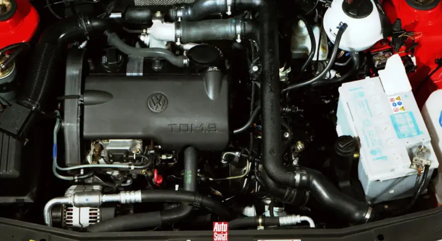 Silnik TDI 1.9 Volkswagena z widocznym akumulatorem i elementami układu dolotowego.