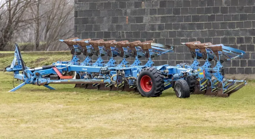 Potężny, niebieski pług 10 skibowy Lemken, gotowy do pracy na polu.