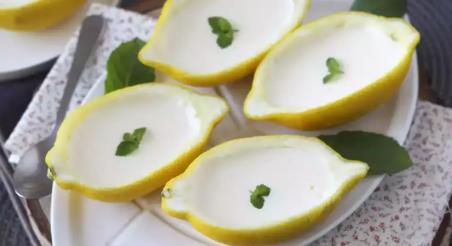 Fyra citroner fyllda med krämig dessert, garnerade med mynta. Perfekt för enklaste julbaket.