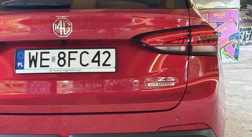 Czerwony tył samochodu MG ZS Hybrid z tablicą rejestracyjną WE 8FC42.