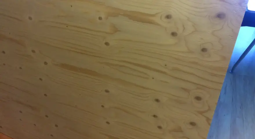 En stor skiva **betsa plywood** med tydliga ådringar och kvistar. Perfekt för ett rustikt projekt.