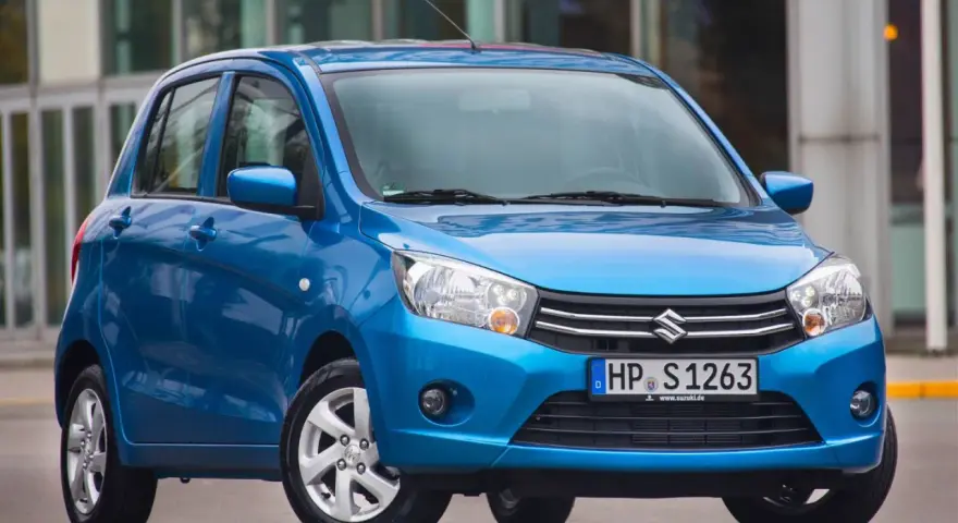 Niebieski Suzuki Celerio stoi przed nowoczesnym budynkiem.