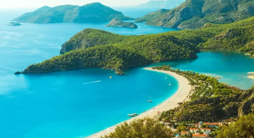 Turcja zachwyca turkusowym morzem i zielonymi wzgórzami. Widok na zatokę z plażą i górami.