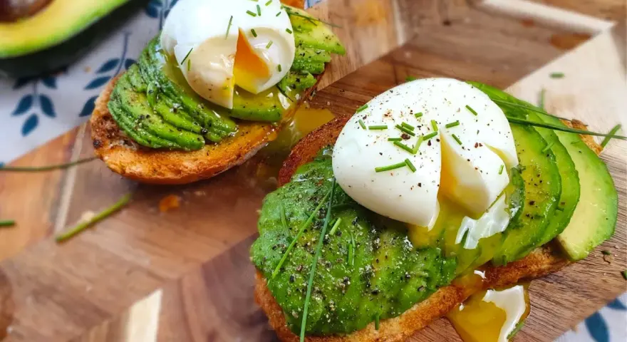 Toast con uova in camicia e avocado, un piatto delizioso e salutare, pronto per essere gustato.