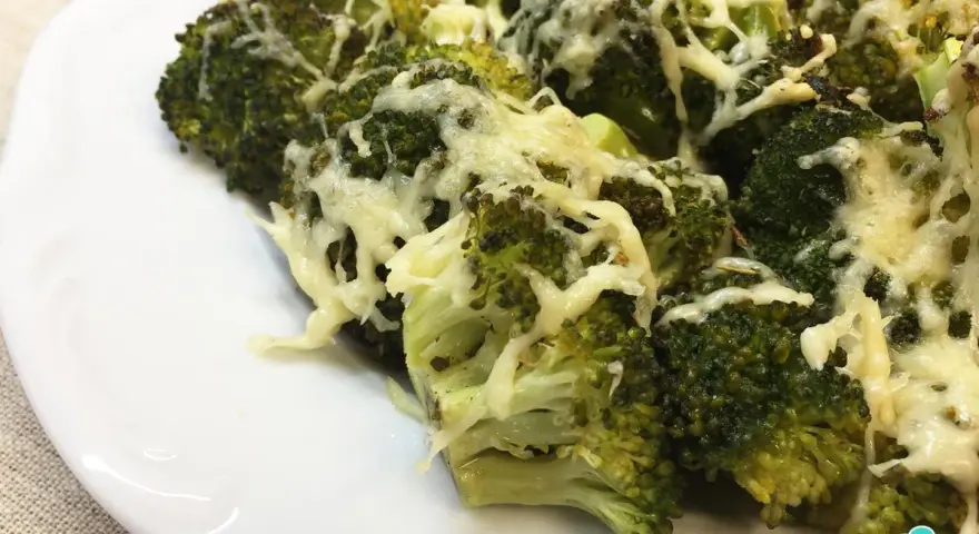 Brocoli al horno gratinado con queso, servido en un plato blanco.