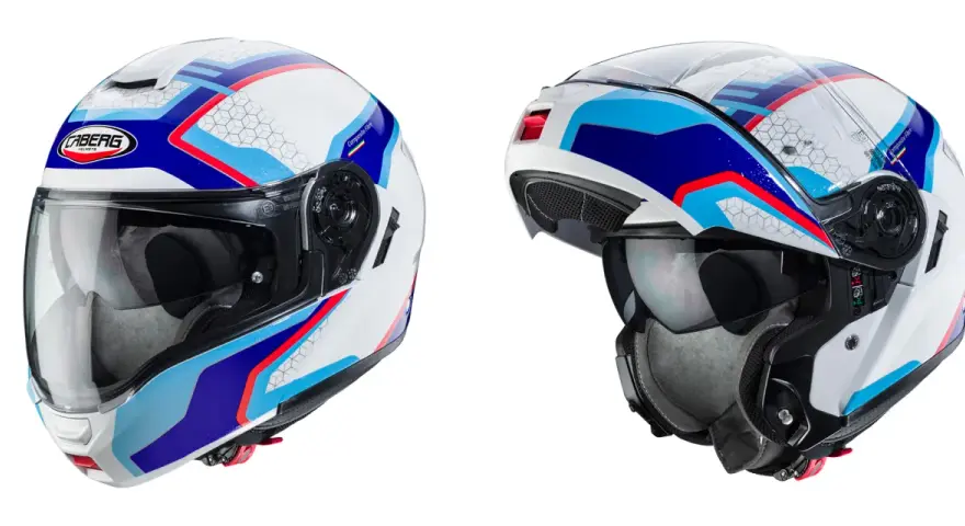 Due caschi integrali Caberg bianchi con grafiche blu, rosse e azzurre. Il casco integrale significa massima protezione.