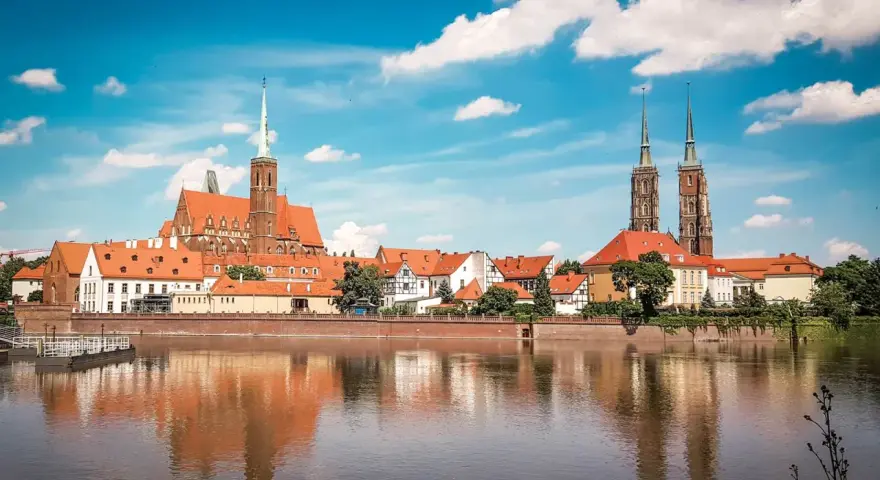 Wrocławskie Ostrów Tumski z katedrą i kościołami, odbijające się w wodzie. W tle widać budynki, które mogłyby pomieścić muzeum sztuki mieszczańskiej.
