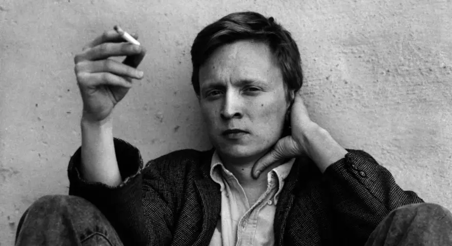 En man med cigarett i handen, Stig Larsson, med handen bakom nacken.