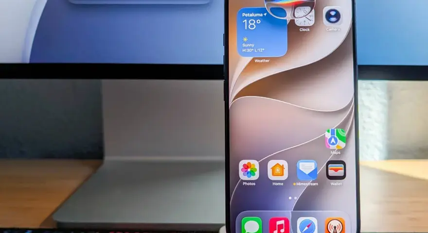 Ein iPhone zeigt Widgets für Wetter, Uhr und Kamera. Die Frage "was kann Siri alles" wird durch die vielen Apps und die Suchleiste auf dem iMac im Hintergrund angedeutet.