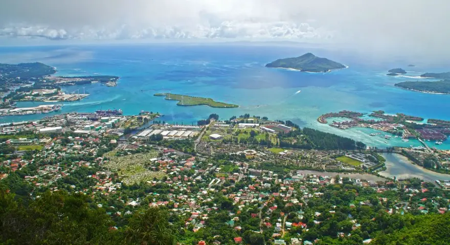 Widok z góry na wyspę z portem, domami i turkusowym morzem. Czy to Seszele, czy Mauritius?