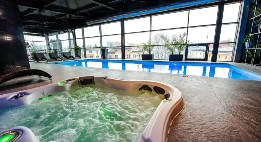 Relaks w hotelowym spa w Białymstoku: jacuzzi z bąbelkami i basen z widokiem na miasto.