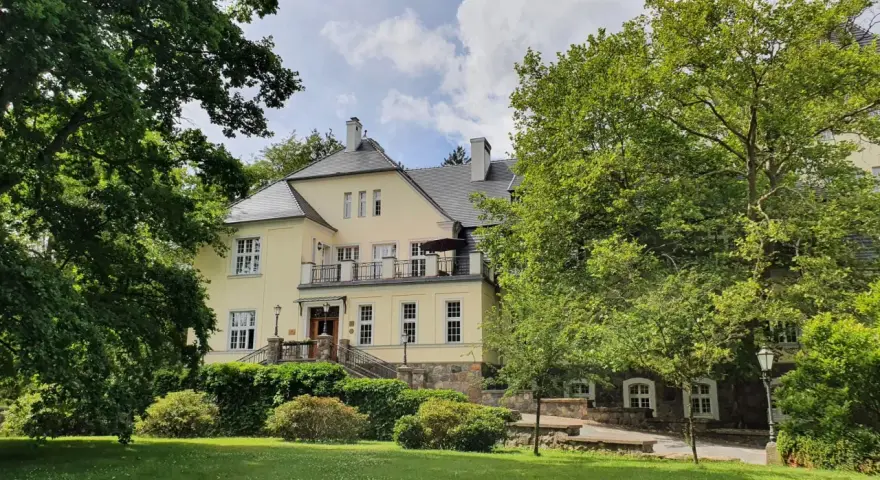 Pałac Ciekocinko, otoczony zielenią, skrywa bogatą historię. Jasna fasada i kamienne detale świadczą o jego przeszłości.