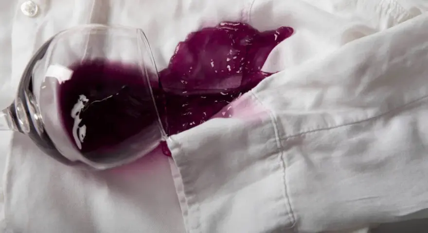 Un bicchiere rovesciato su una camicia bianca ha creato una macchia di vino rosso. Ecco come togliere macchie vino rosso secche.