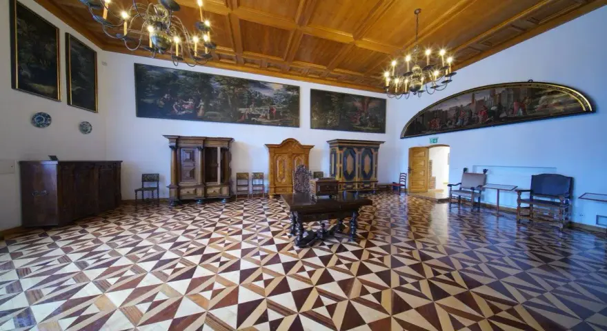 Wnętrze muzeum Gdańska - Ratusz Głównego Miasta. Bogato zdobiona sala z zabytkowymi meblami, obrazami i misterną parkietową posadzką.