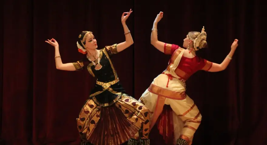 Anna Łopatowska i partnerka w tradycyjnych strojach tańczą taniec klasyczny Bharatanatyam.