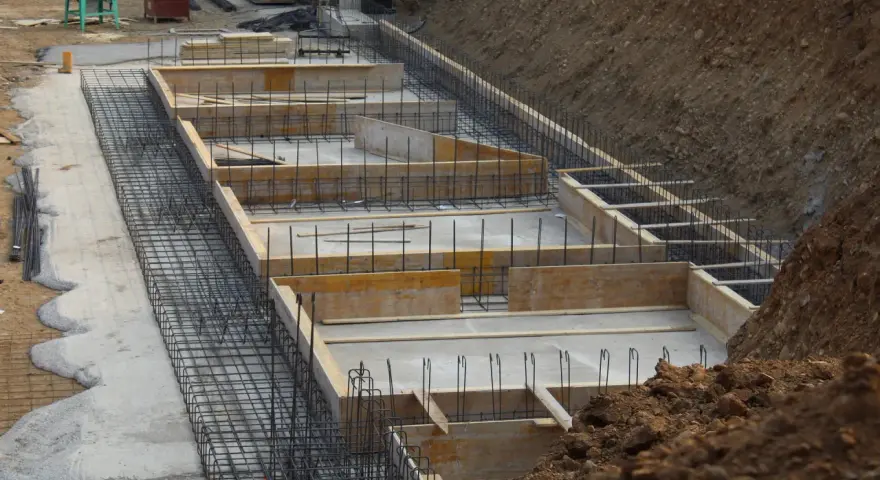 Szkielet zbrojeniowy i szalunki czekają na beton. Widać, ile bloczków na fundament potrzeba do budowy.