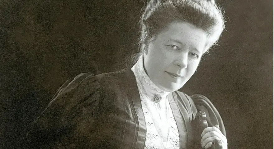 Selma Lagerlöf, med sin karaktäristiska frisyr och klädedräkt, blickar mot betraktaren.