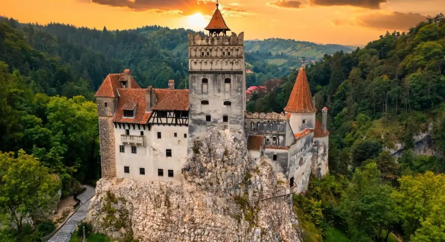 Majestatyczny zamek w Transylwanii, górujący nad lasami o zachodzie słońca.