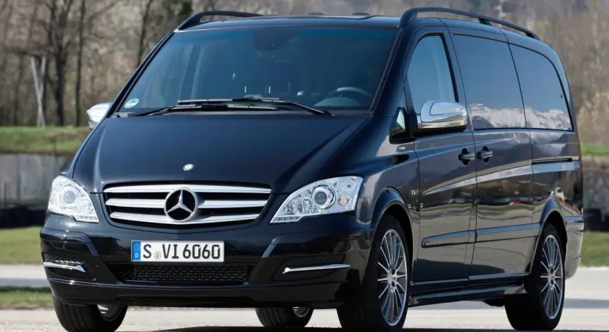 Czarny Mercedes Viano 3.0 V6 z przyciemnianymi szybami i relingami dachowymi, gotowy na podróż.