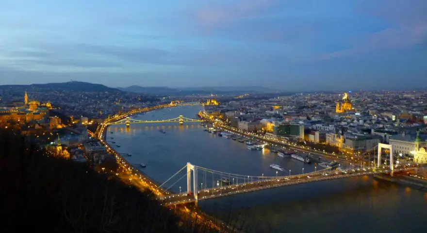 Vista nocturna de Budapest con el río Danubio y sus puentes iluminados, creando un paisaje urbano mágico.