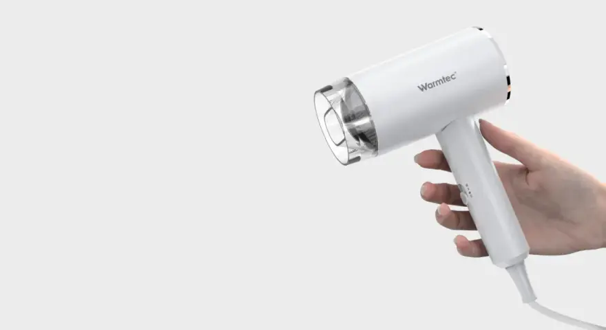 Biała suszarka Warmtec trzymana w dłoni.