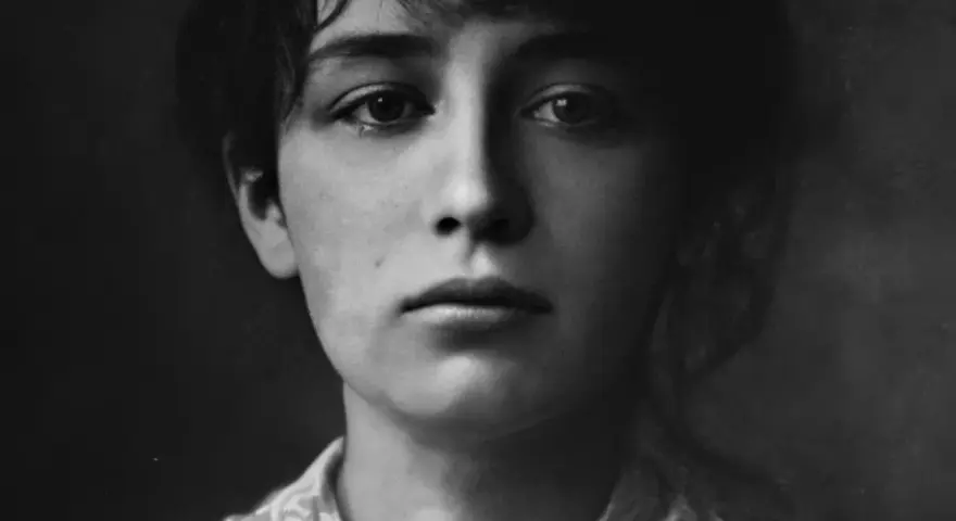 Portret młodej Camille Claudel, zamyślonej, z delikatnym uśmiechem.