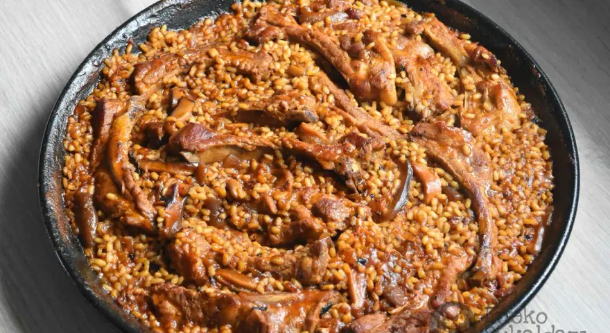 Arroz con costillas y champiñones, un plato sabroso y reconfortante, listo para ser disfrutado.