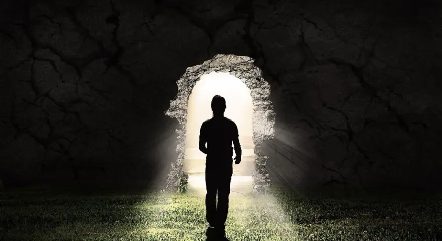 Ein Mann im Schatten tritt aus einer Höhle ins Licht. LK 21.