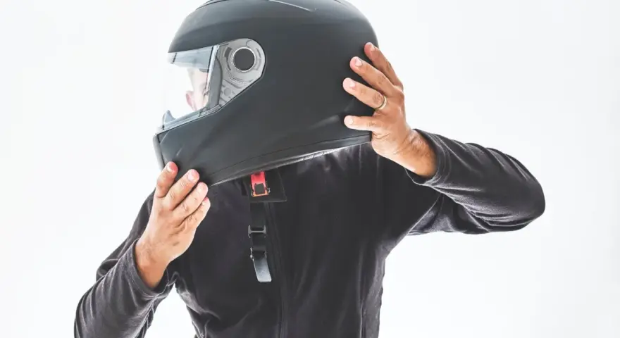 Persona indossa un casco integrale nero, pronto per un giro in moto.