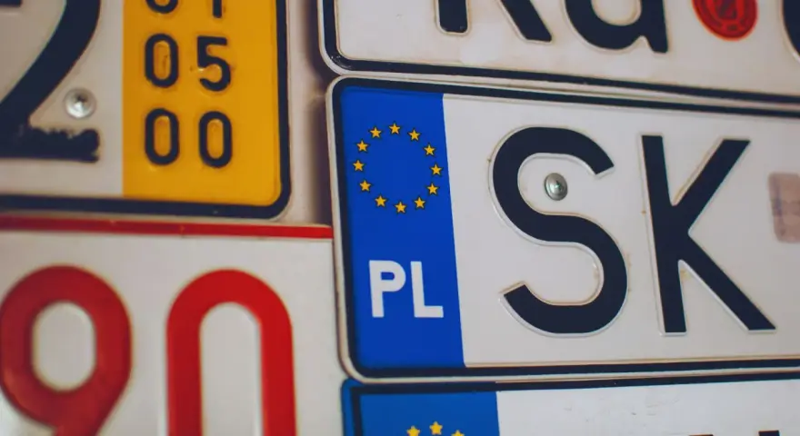Kolekcja tablic rejestracyjnych, w tym polska z symbolem UE i oznaczeniem PL.