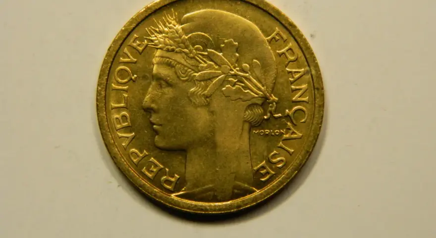 Une pièce de 1 franc 1948, en or, avec le profil d'une femme couronnée de blé. "République Française" est gravé sur le pourtour.