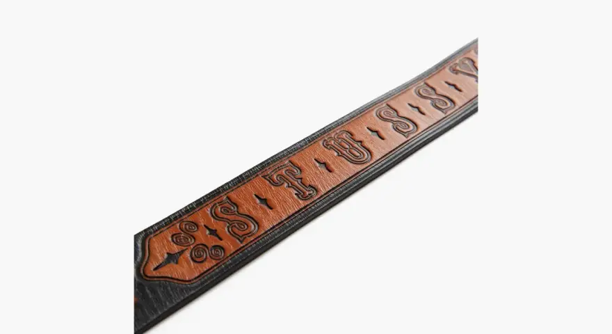 Cintura in pelle marrone con logo Stussy inciso e dettagli decorativi.