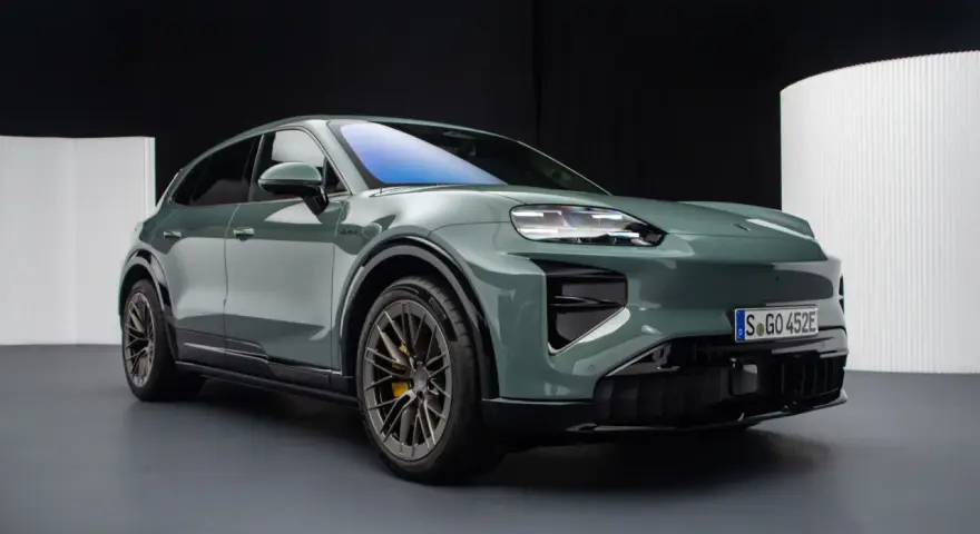 Zielony elektryczny Porsche Macan na ciemnym tle.