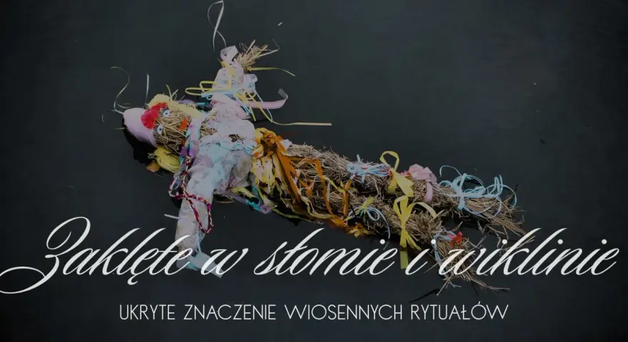 Słomiana kukła z kolorowymi wstążkami, symbol wiosennego obrzędu ludowego, pływa na ciemnej wodzie.