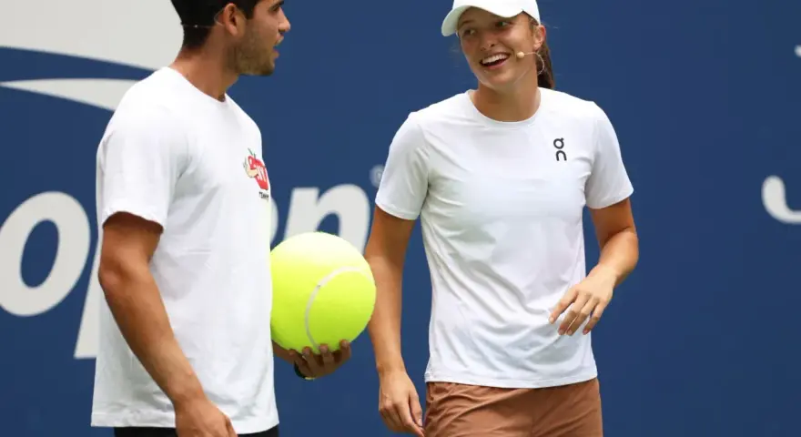 Carlos Alcaraz i Iga Świątek rozmawiają podczas Roland Garros 2024. Carlos trzyma wielką piłkę tenisową.