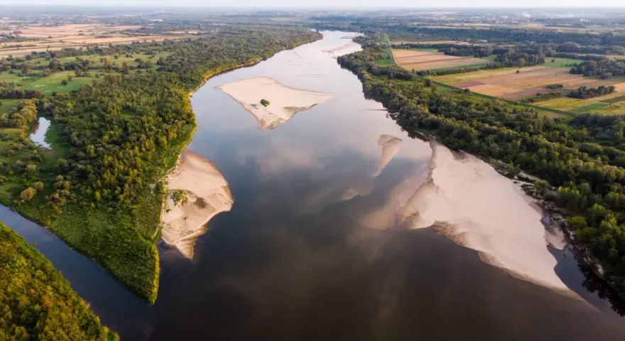 Szeroka Wisła, najdłuższa rzeka w Polsce, meandruje wśród zielonych lasów i piaszczystych łach.