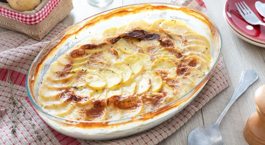 Un gratin dauphinois doré et crémeux, digne d'une recette de Cyril Lignac, prêt à être dégusté.