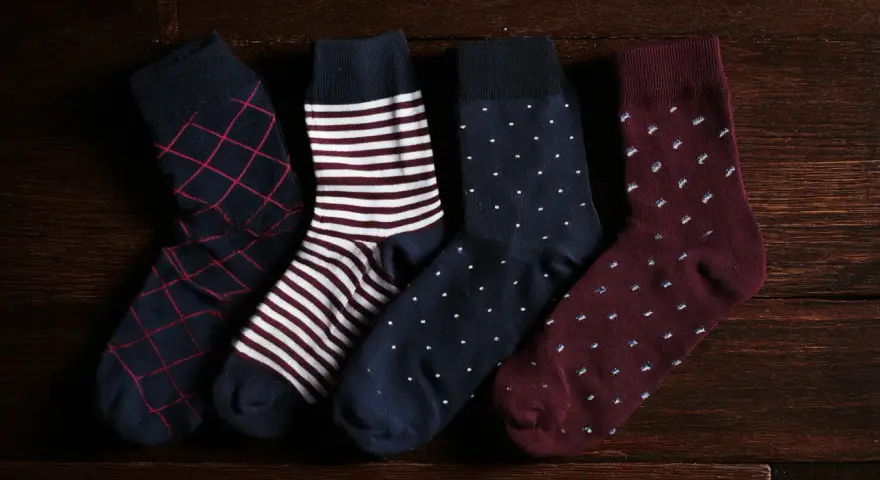 Quattro paia di calzini da uomo con fantasie diverse: rombi, righe, pois. Perfetti da abbinare a un abito elegante.