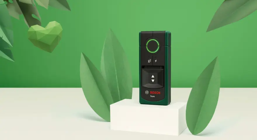 El detector Bosch Truvo, uno de los tipos de detectores, se muestra rodeado de hojas verdes y un corazón de papel.