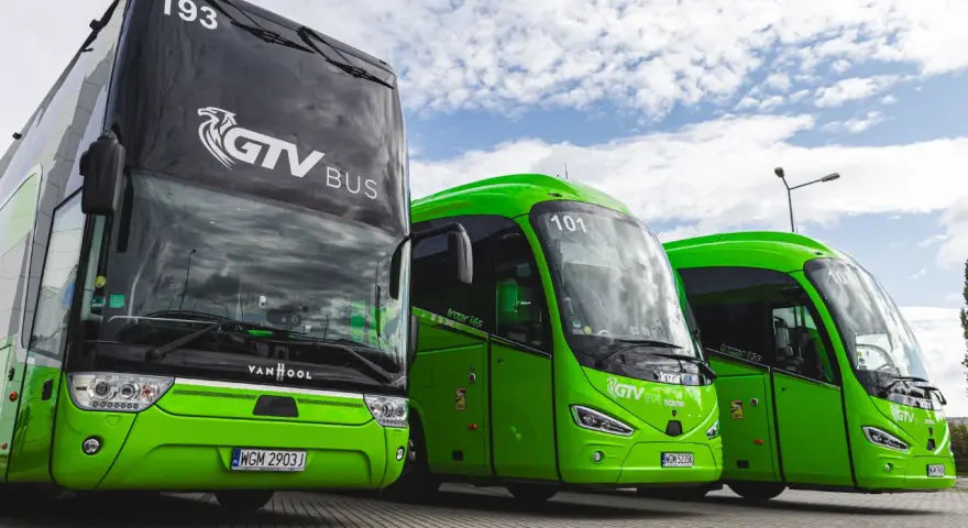 Trzy zielone autokary GTV Bus stoją obok siebie. Sprawdź neobus rozkład jazdy i zaplanuj podróż!