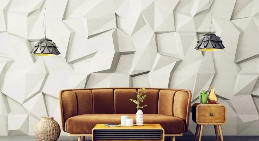 Sofá marrón y mesa de centro con elementos decorativos frente a una pared con relieve que combina papel pintado y pintura.