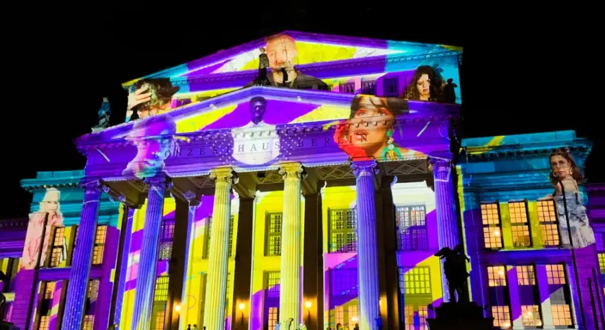 Das Konzerthaus Berlin erstrahlt in bunten Farben bei der "Berlin Nacht der Lichter". Gesichter und Muster projiziert auf die Fassade.