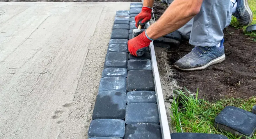 Układanie kostki brukowej na podsypce piaskowej to kluczowy etap, by wiedzieć, na czym postawić garaż blaszany.