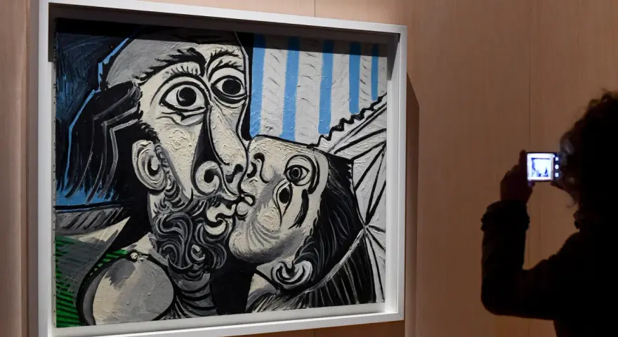Un visitante captura con su móvil uno de los icónicos cuadros de Picasso, un beso en blanco y negro con toques de azul.