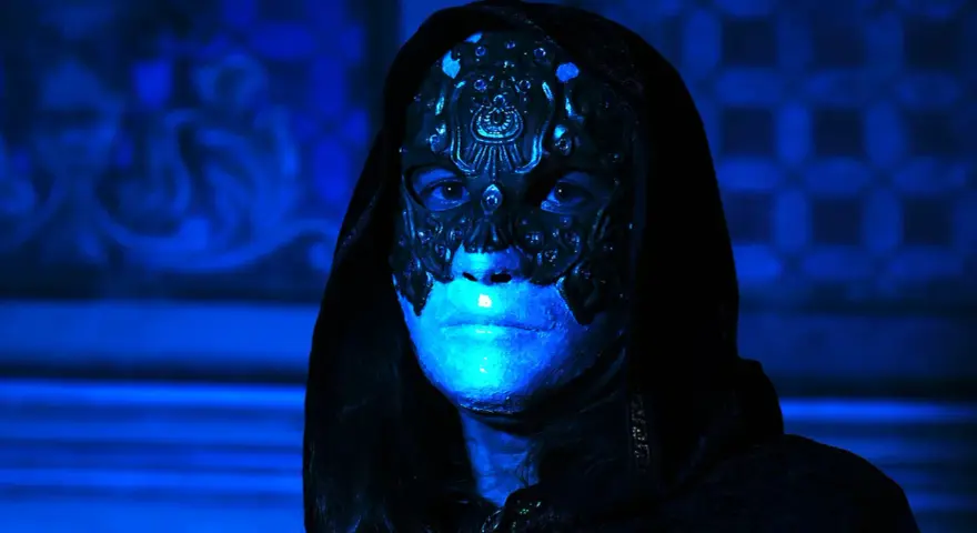 Volto mascherato con illuminazione blu intensa, un'immagine che evoca mistero e terrore, perfetta per i film horror più visti.