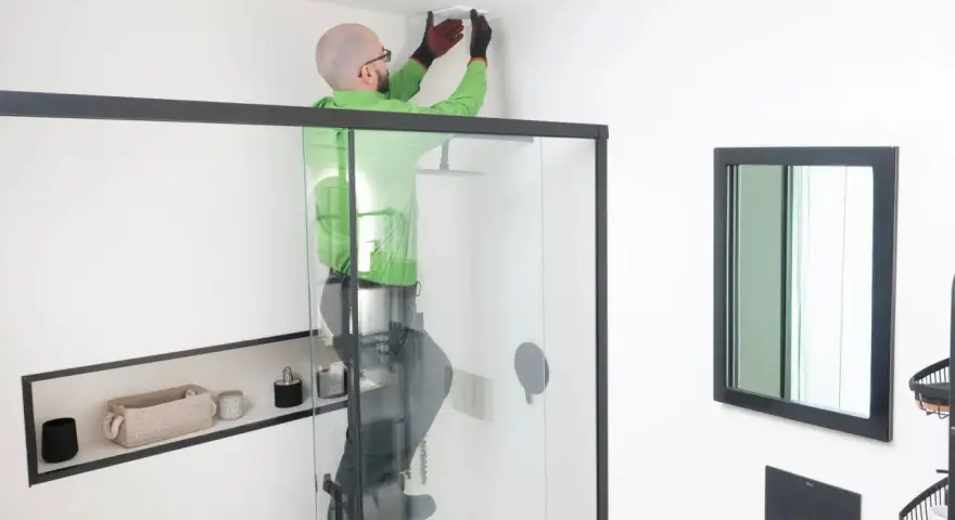 Hombre instala extractor baño en el techo.
