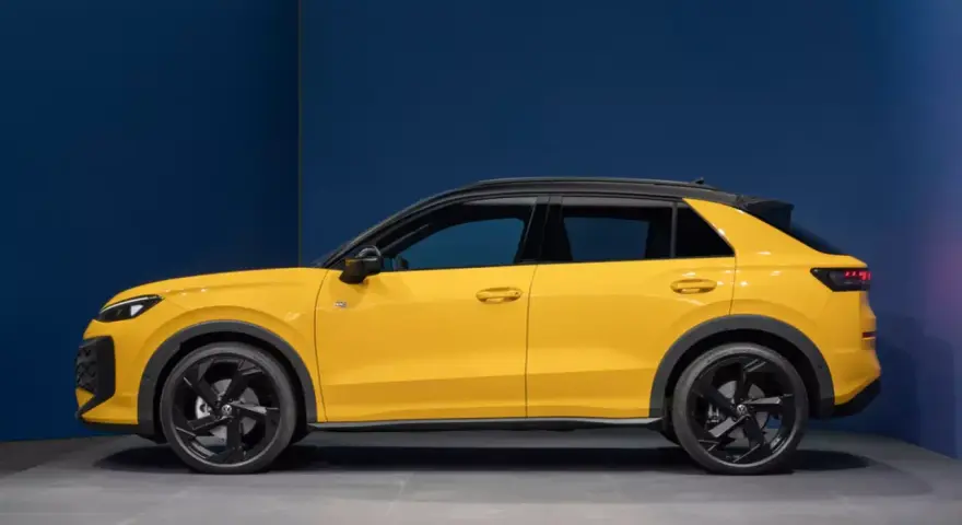 Nowy żółty Volkswagen T-Roc z czarnym dachem, widziany z boku.