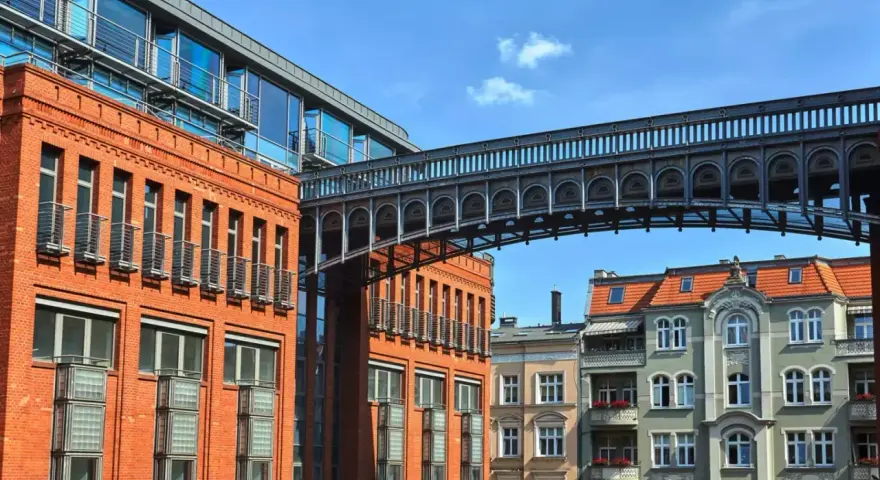 Nowoczesna architektura przeplata się z kamienicami, tworząc ciekawe **ukryte miejsca w Poznaniu**. Metalowy mostek łączy budynki.