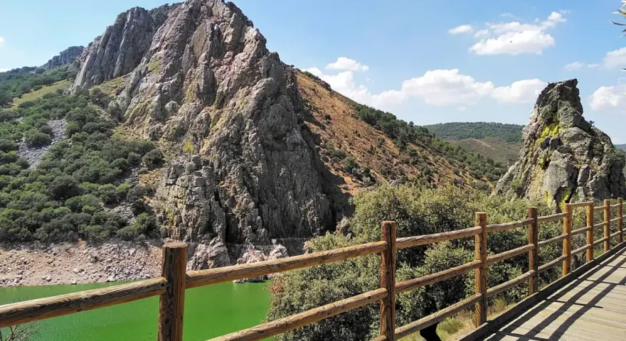 Impresionante paisaje de un parque protegido con imponentes rocas, vegetación frondosa y un río de aguas verdes.
