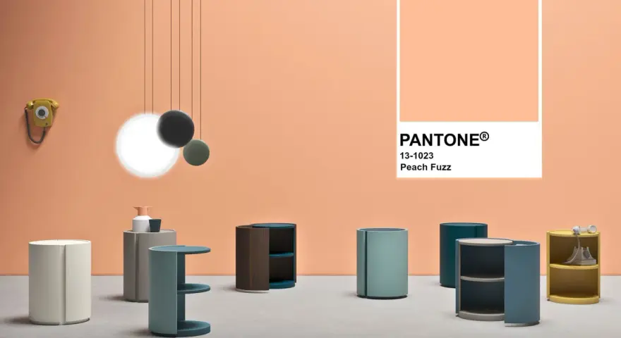 Arredamento moderno su sfondo color pesca Pantone. Tavolini cilindrici e un telefono vintage.